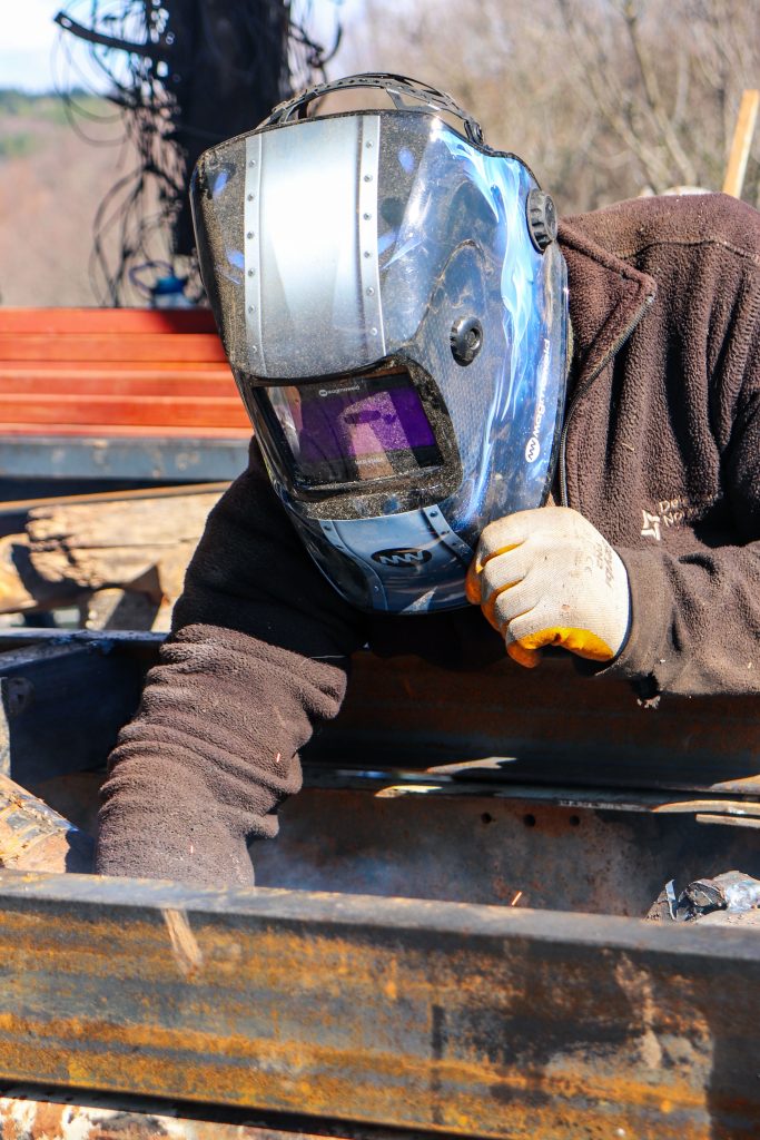 Soudeur travaillant une pièce métallique en atelier